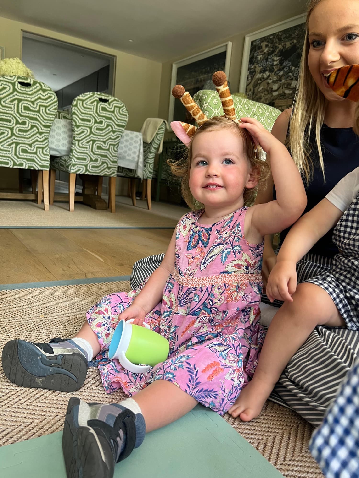 A toddler delighted by a reindeer antler headband