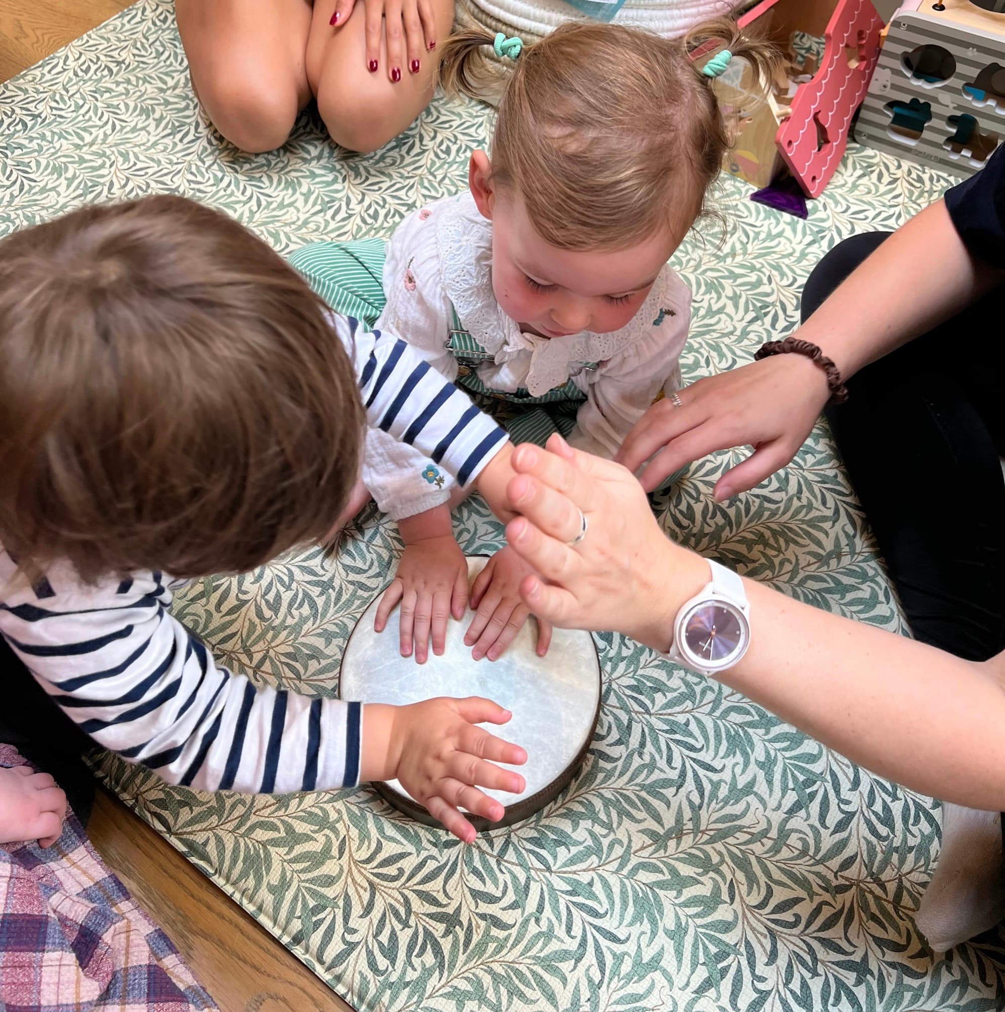 Little hands exploring a tambourine together